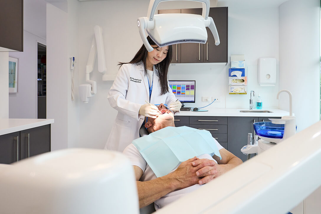 dentist checking on teeth of client | Endodontist Clinic Sydney